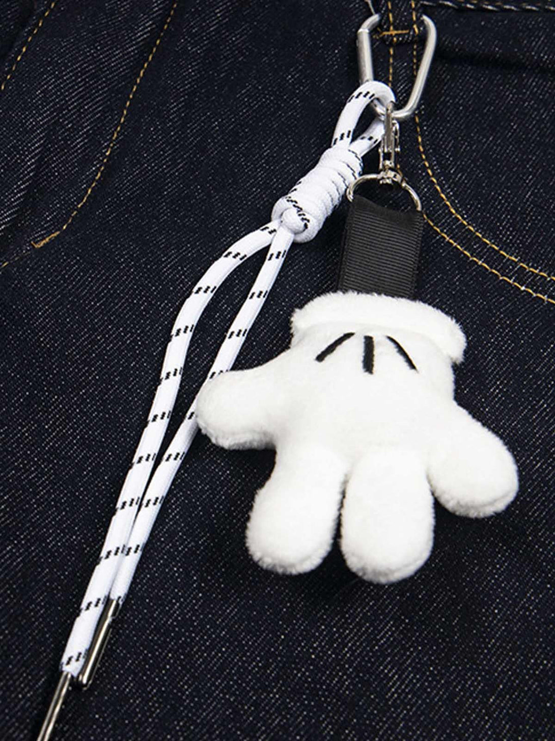 TALISHKO keychain with white glove detail attached to denim jeans, highlighting playful style.