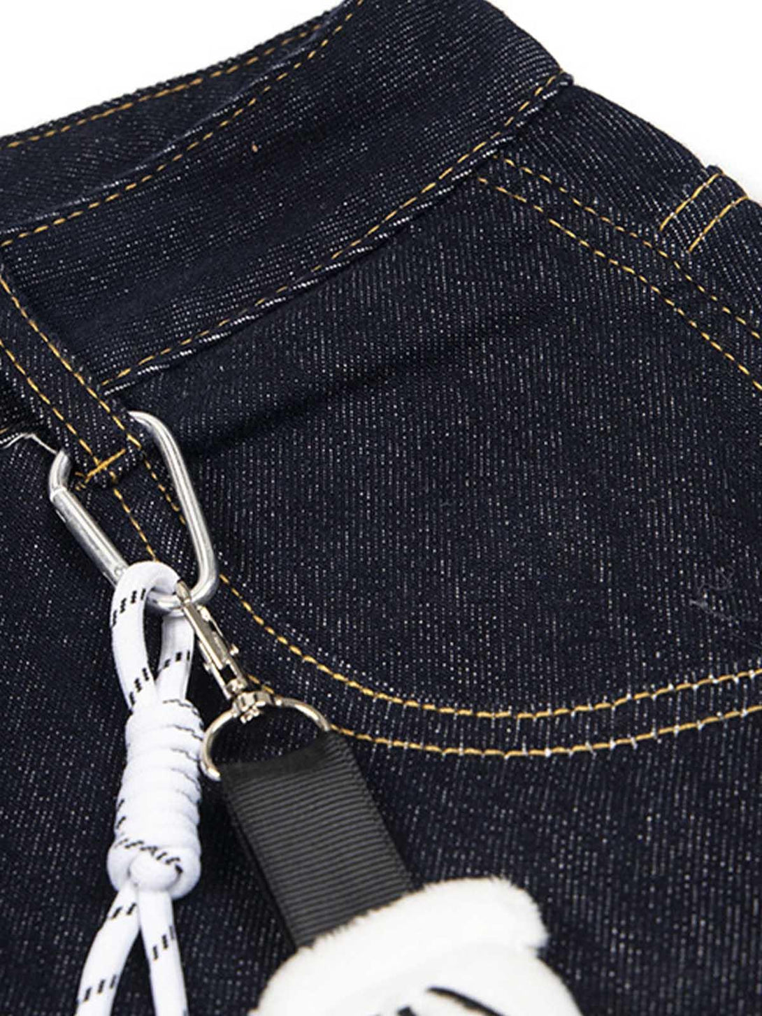Detailed view of TALISHKO jeans pocket with keychain and stitching, showcasing playful design.
