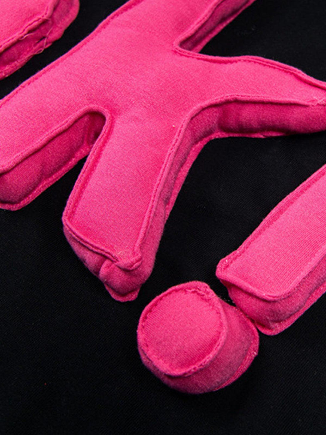Zoomed-in texture of a black T-shirt, highlighting the bold pink "OK!" design by TALISHKO.