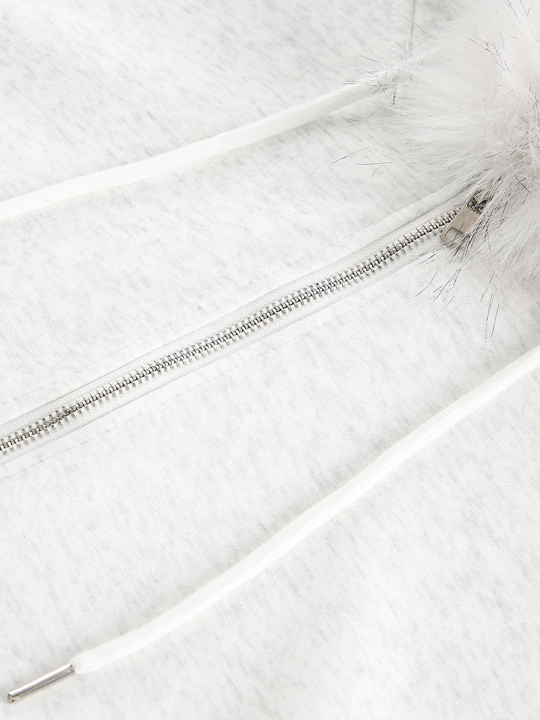 Intricate look at the zipper and drawstring details on a TALISHKO cardigan, showcasing craftsmanship.