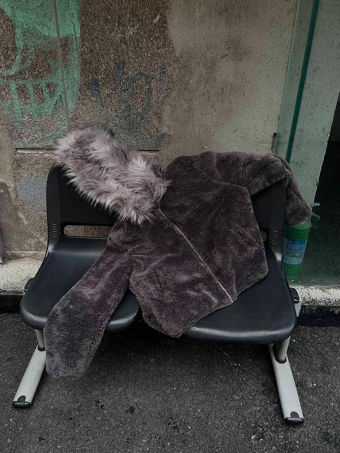 A plush sherpa jacket with a soft faux fur hood draped on a bench, by TALISHKO.