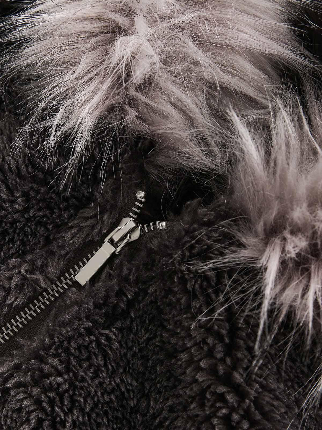 A detailed view of TALISHKO's plush sherpa jacket with a soft faux fur hood and zipper.