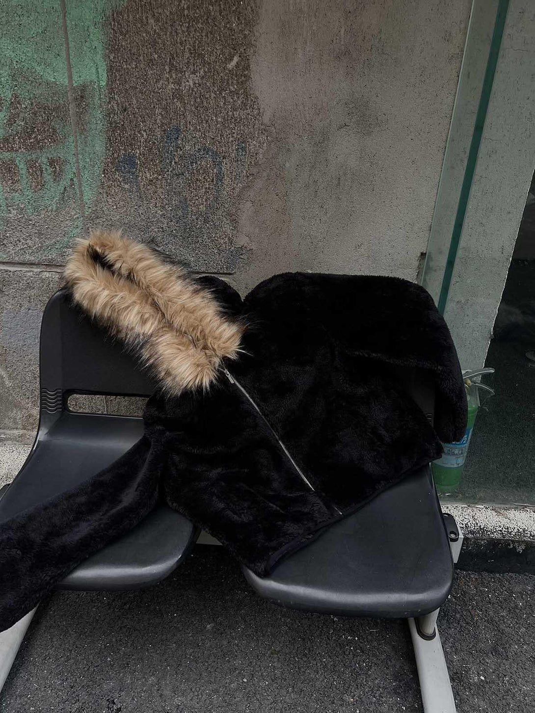 TALISHKO's stylish sherpa jacket with a faux fur hood casually draped over a bench.