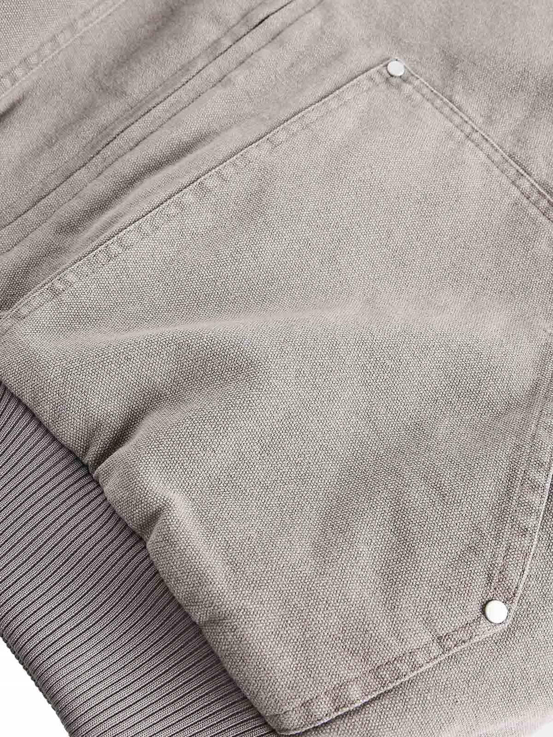 "Zoomed-in texture of TALISHKO's quilted jacket pocket, highlighting fabric and stitch detail."