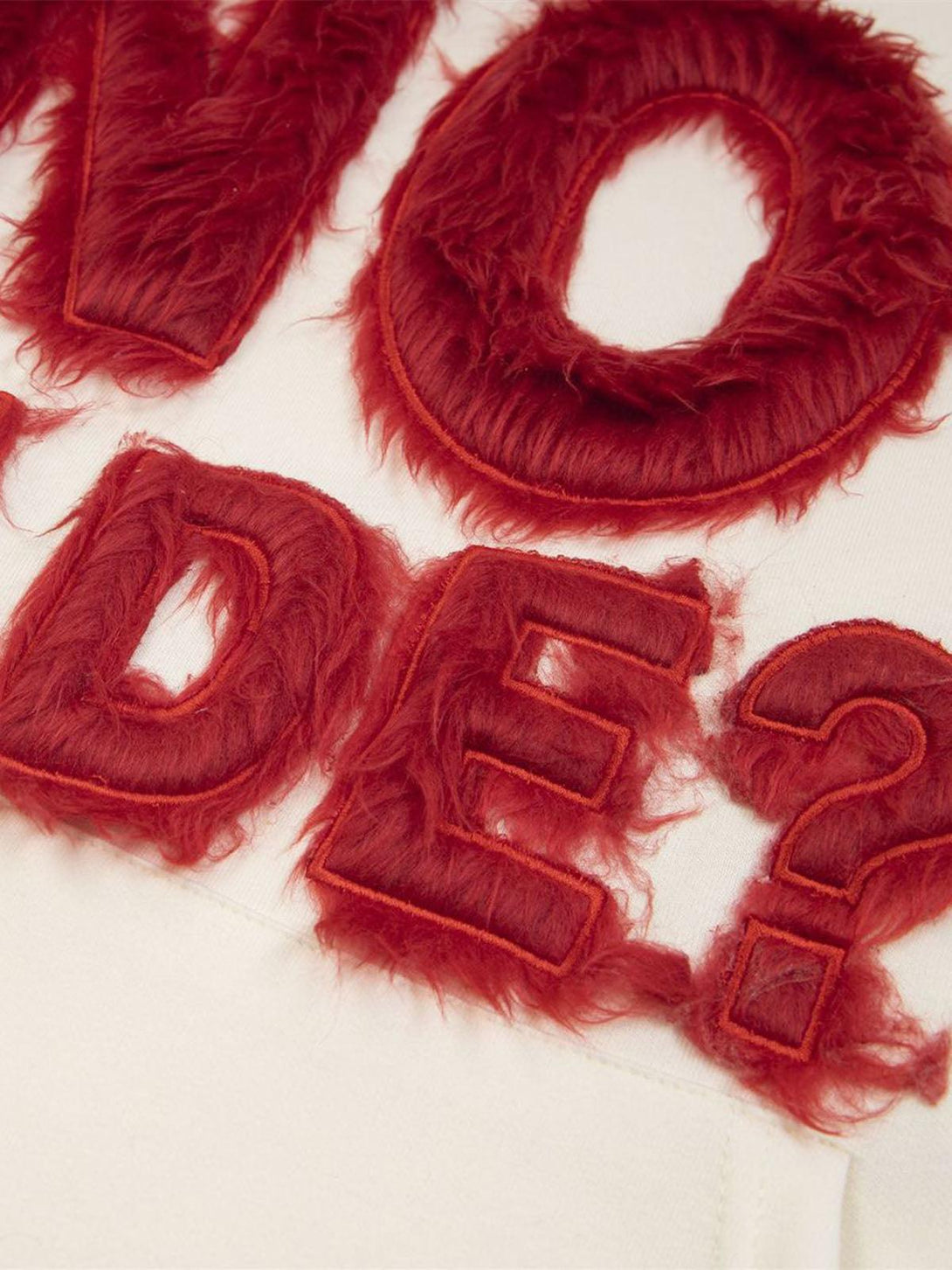 Intricate look at red fur patchwork embroidery detail on a hoodie by TALISHKO.