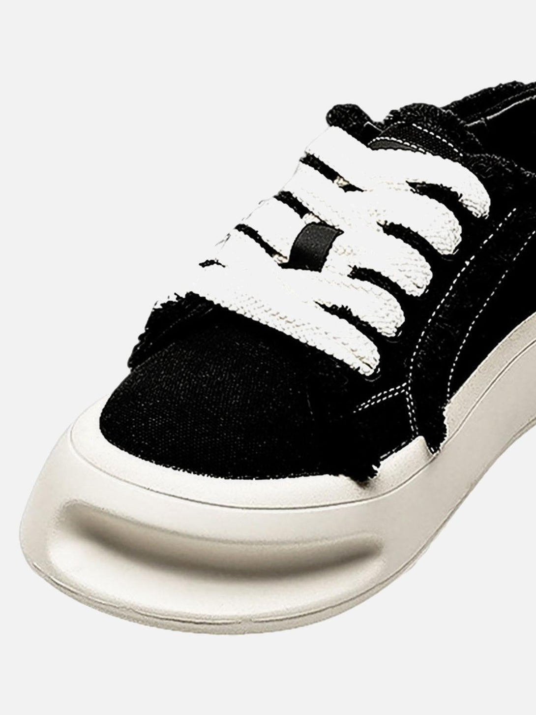 Close-up of TALISHKO's fuzzy trim chunk shoe showcasing bold white laces and unique sole design.
