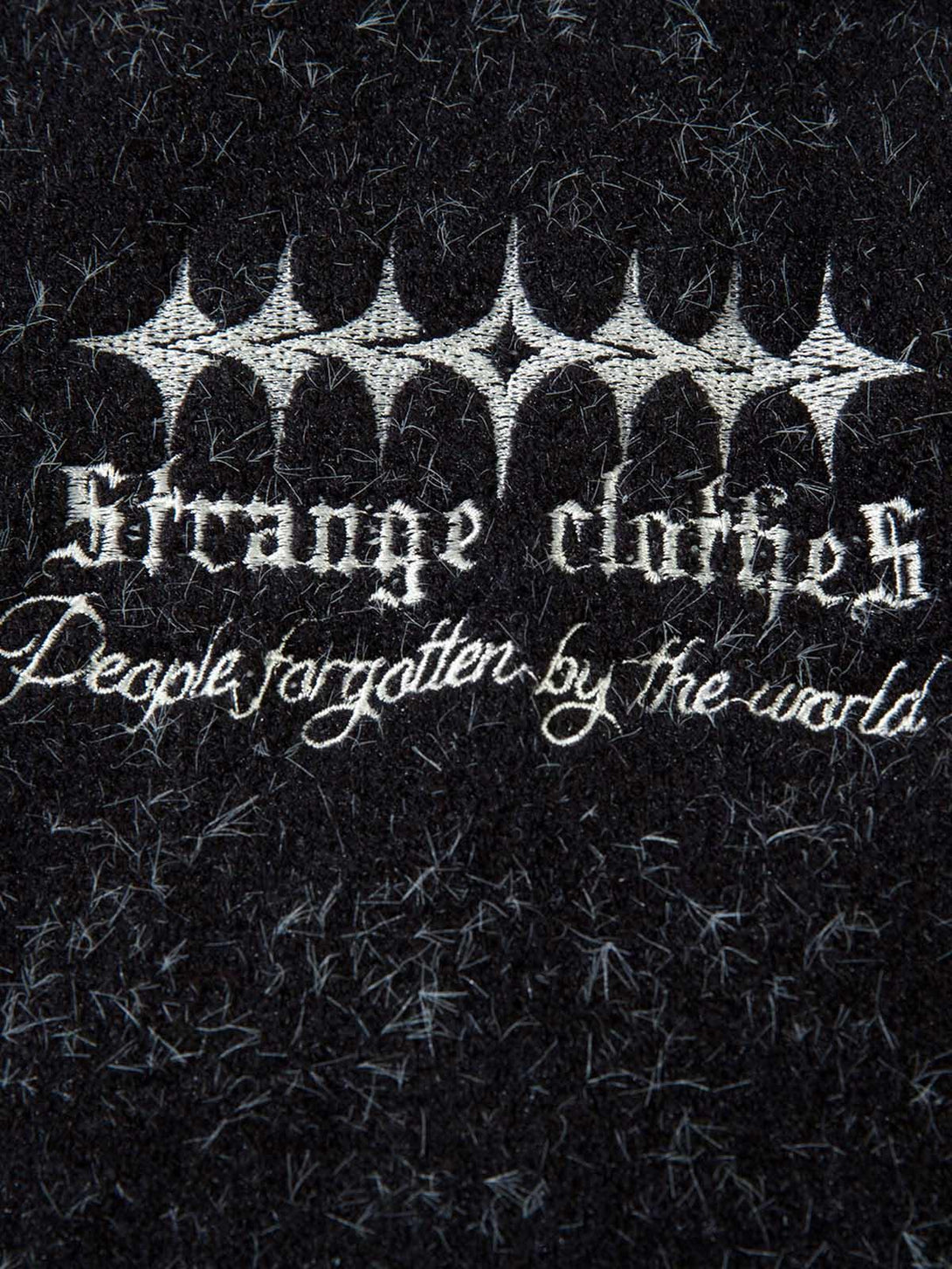 Intricate design detail on TALISHKO's fuzzy sweater, showcasing unique embroidery and texture.