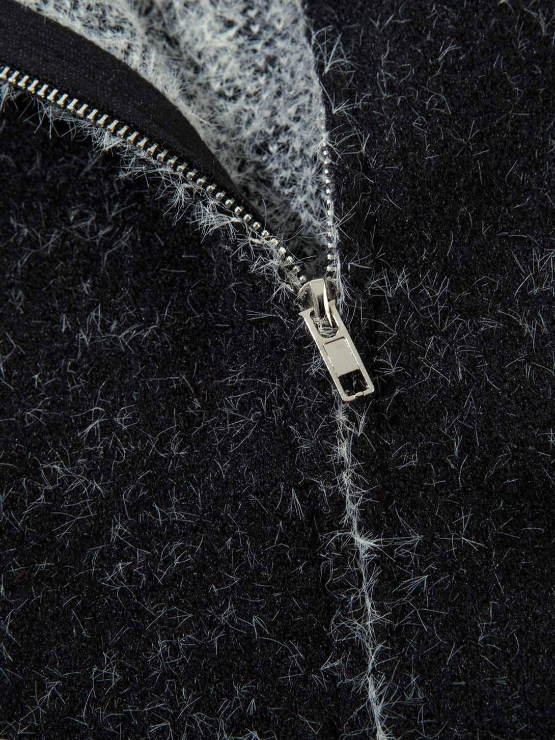 A detailed view of TALISHKO's fuzzy zipper hooded sweater, highlighting the intricate texture.