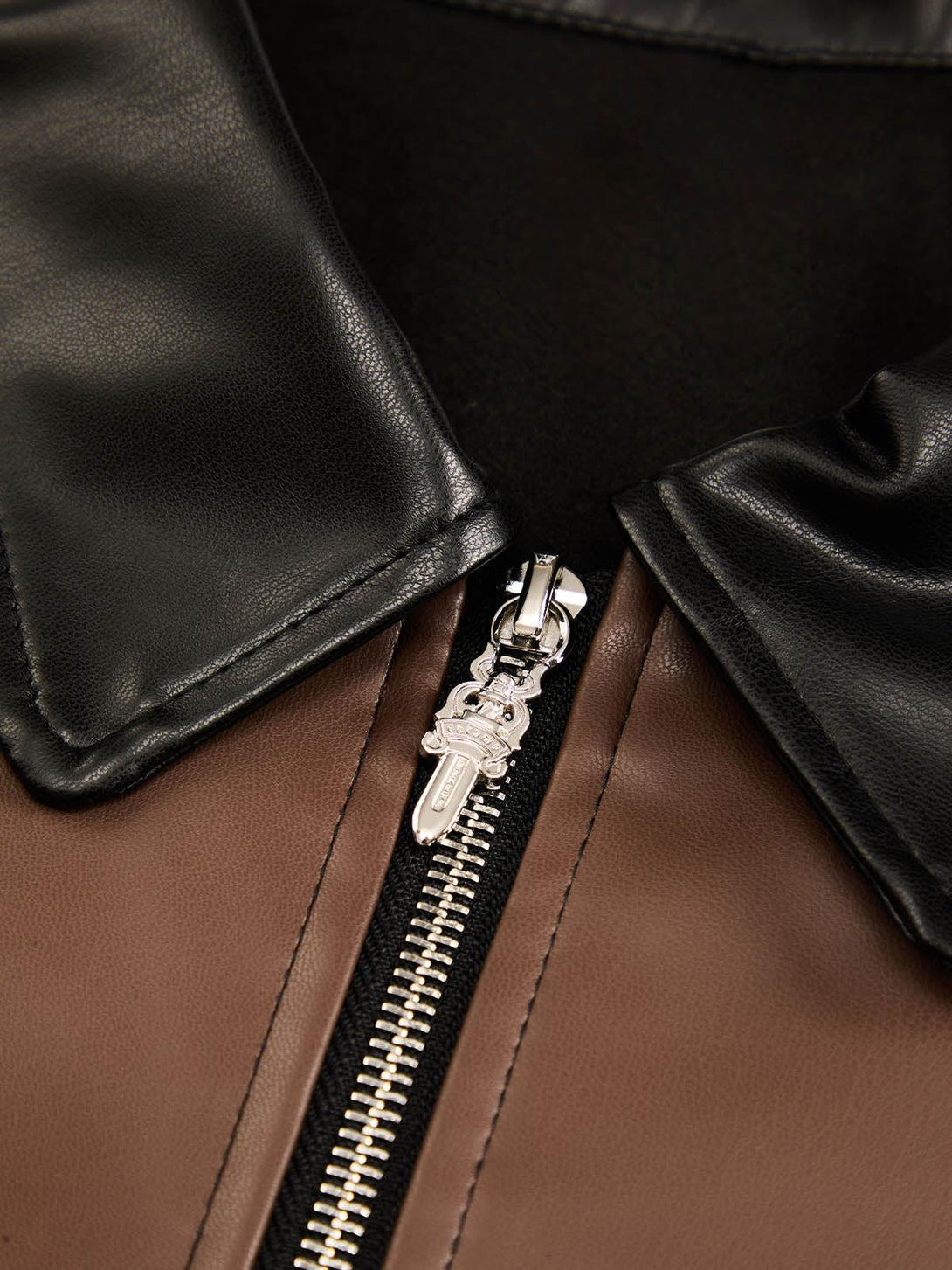 Focusing on the zipper detail of a TALISHKO leather shirt, highlighting contrast textures.