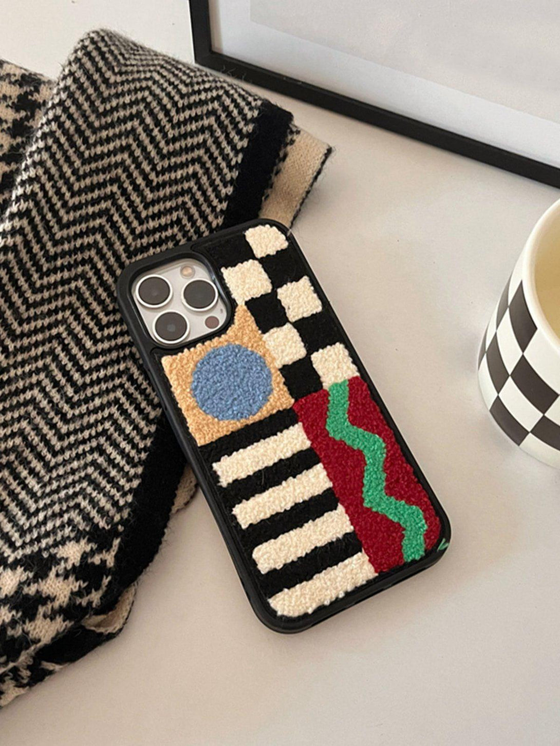 TALISHKO phone case with vibrant geometric patchwork design, showcasing plush textures and bold patterns.