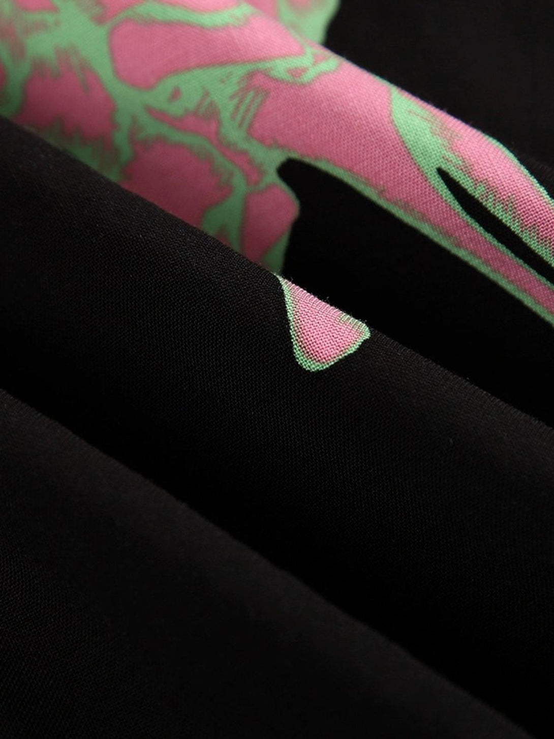 Intricate look at TALISHKO shirt's pink and green ghost claw print on black fabric.