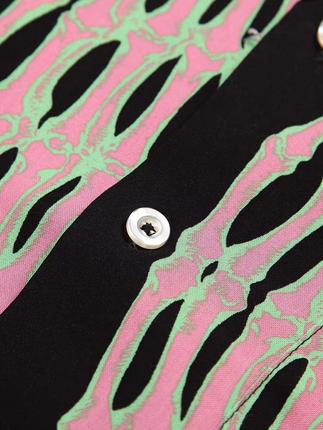 A detailed view of the TALISHKO shirt showcasing vibrant ghost claw patterns on black fabric.