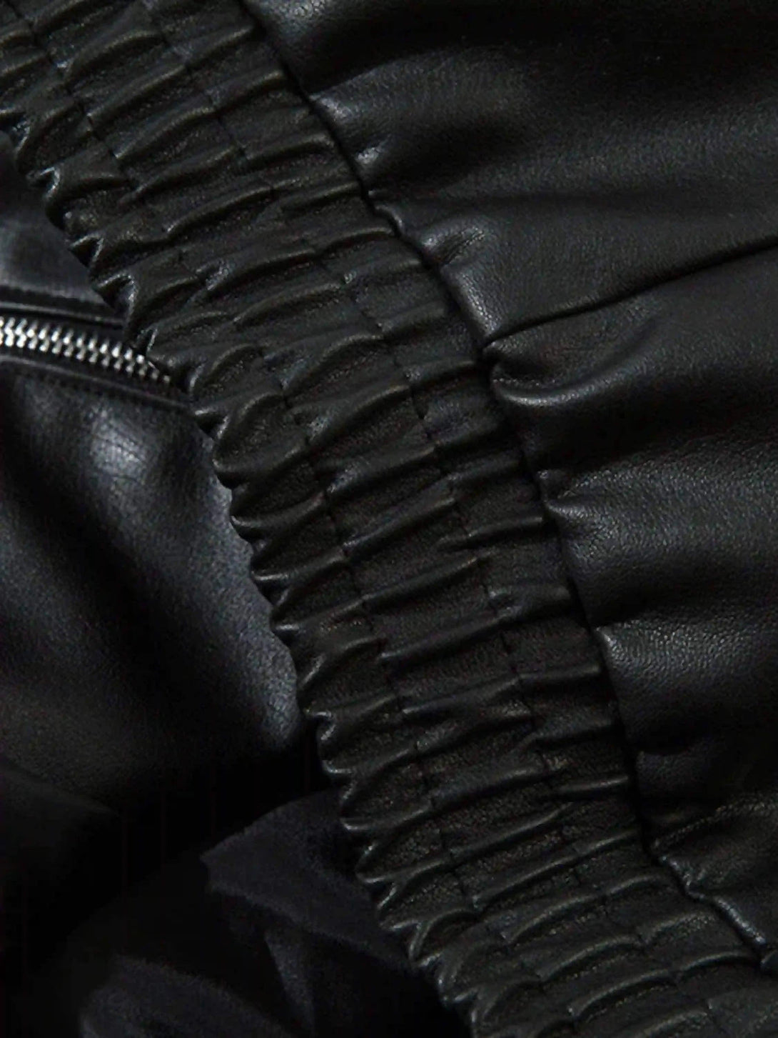 Elastic detail of TALISHKO's racing collar jacket, showcasing luxurious black leather texture.