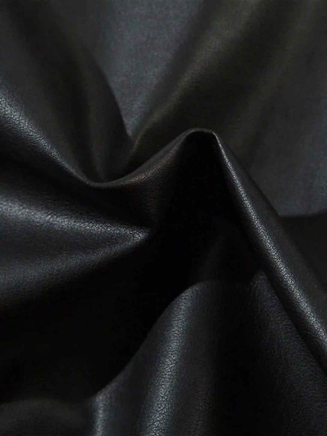 Luxurious black leather texture of TALISHKO's jacket, highlighting its sleek, glossy finish.