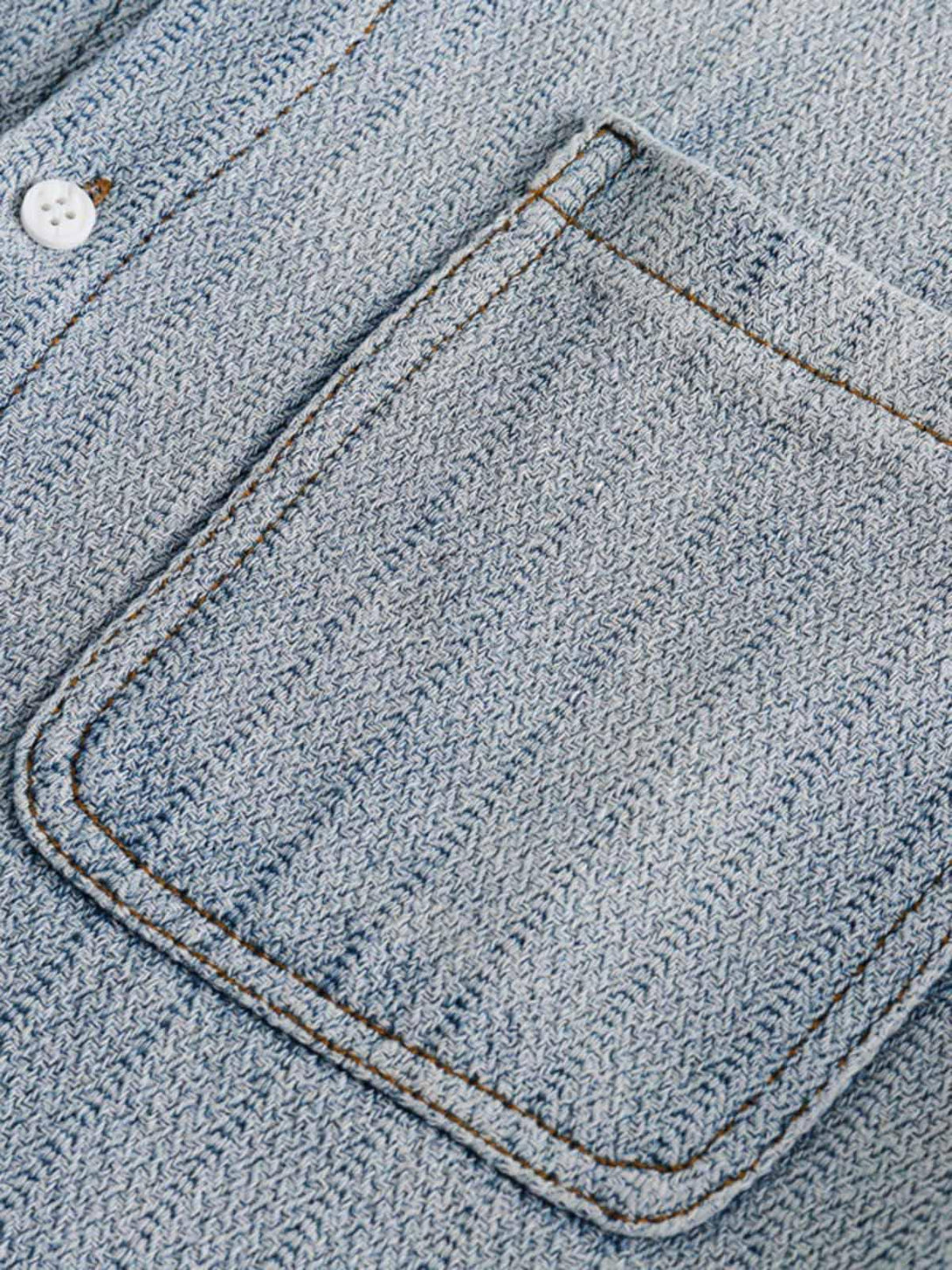 Focusing on the pocket detail of TALISHKO's gradient denim shirt, showcasing texture and stitching.