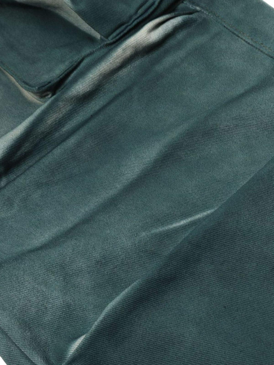 A close-up of TALISHKO cargo jeans, showcasing the gradient dip dye and textured fabric.