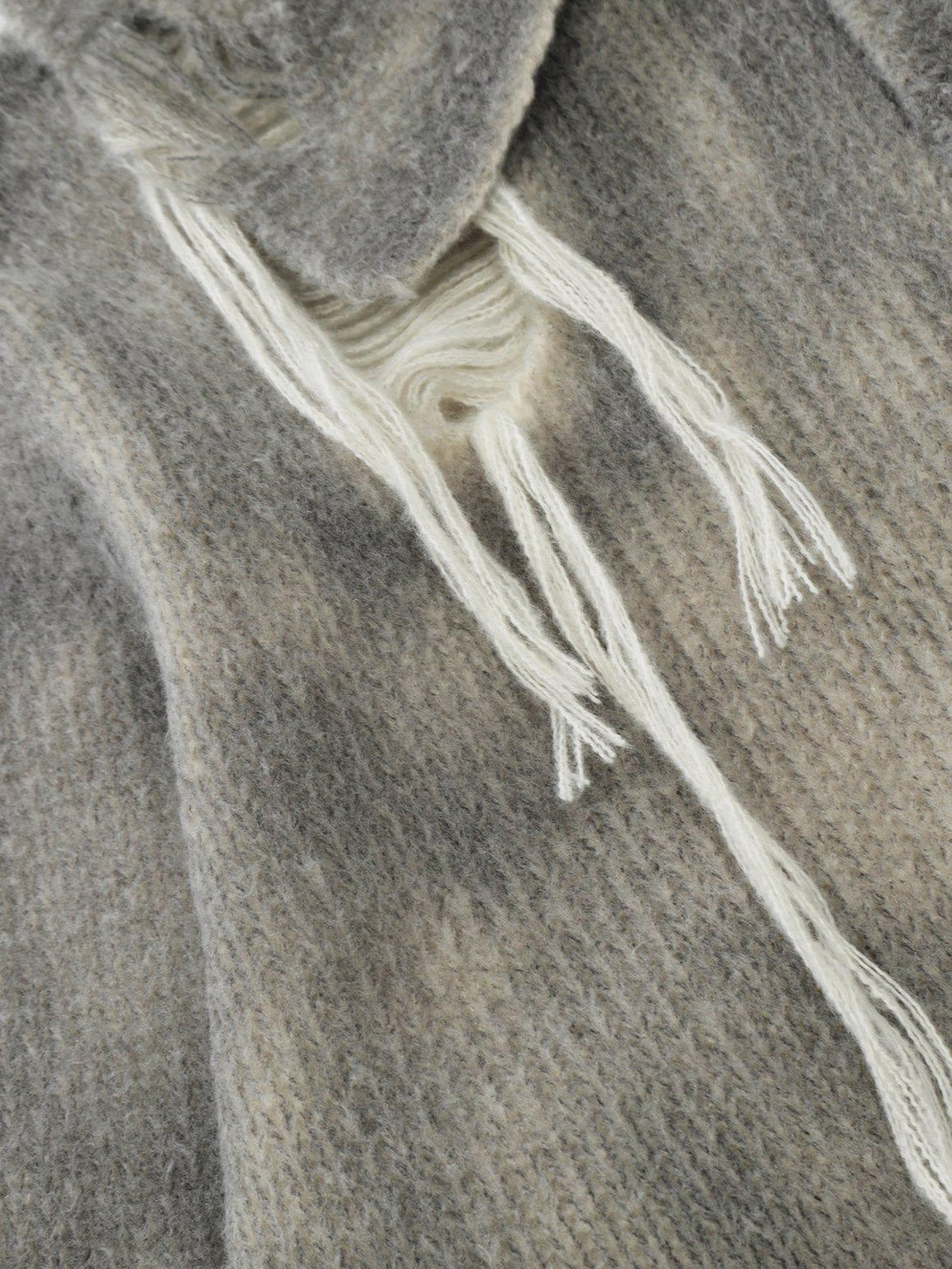 A detailed view of TALISHKO's gradient distressed polo sweater, showcasing its textured design.