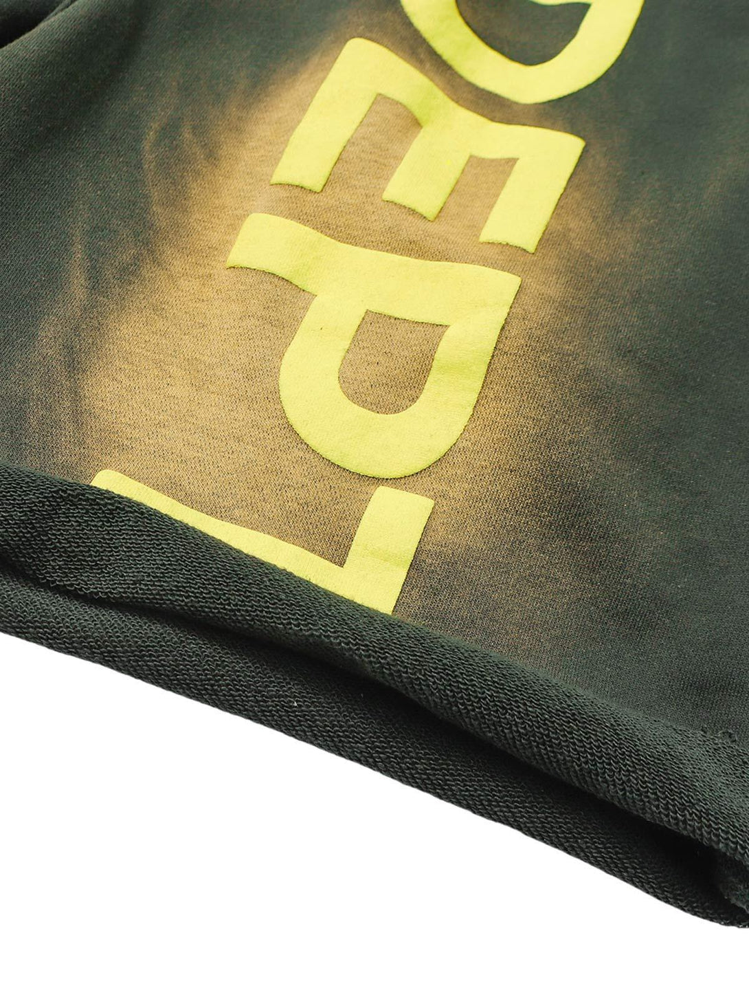 A tight crop highlighting TALISHKO's gradient letter print on drawstring shorts fabric.