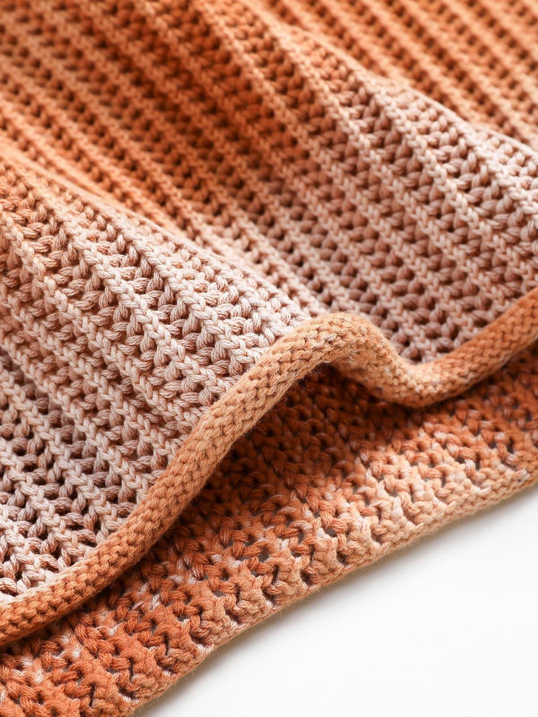 Detailed fabric and stitching of TALISHKO's gradient ombre knit sweater, highlighting texture.