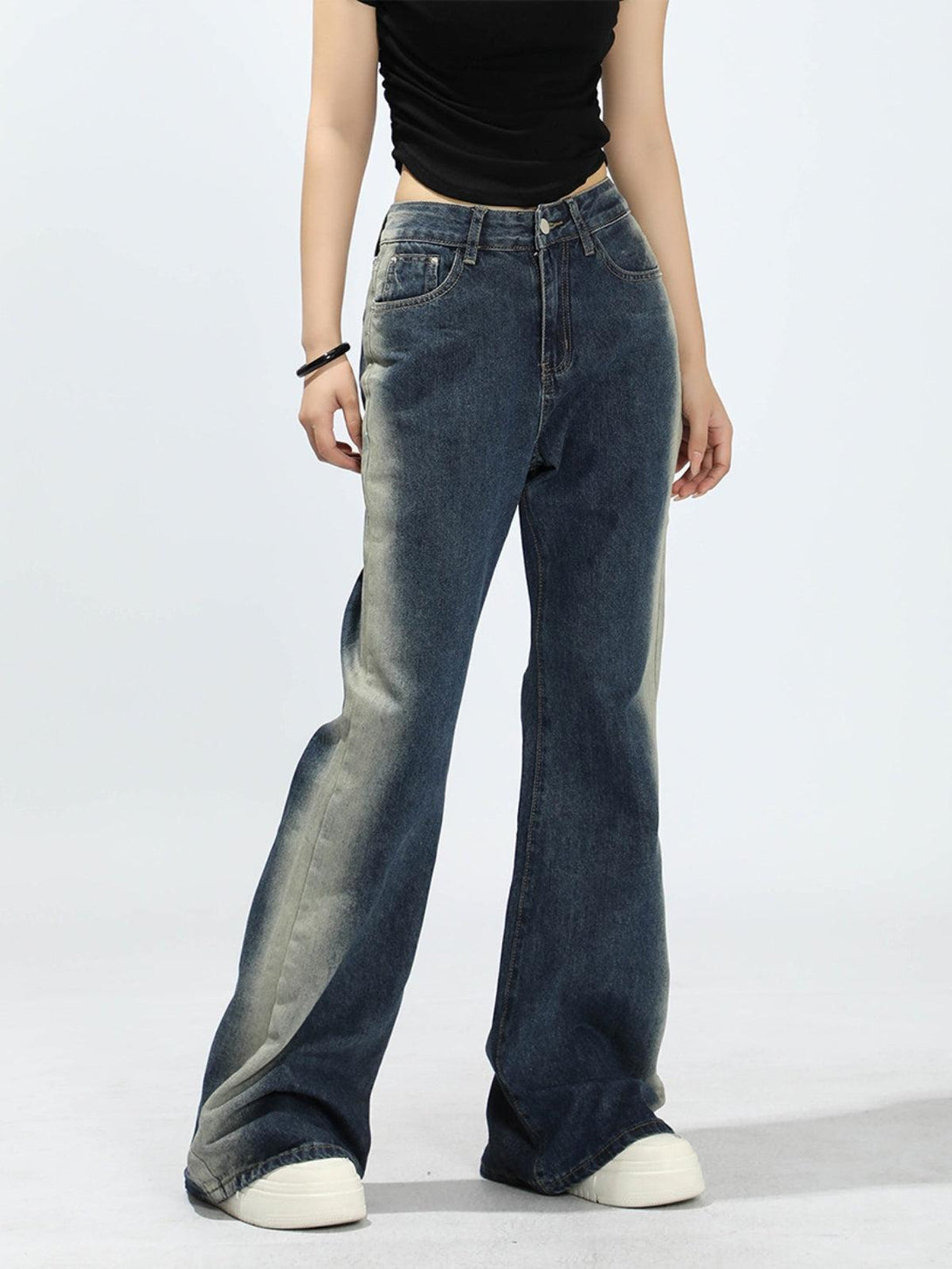 Model wearing TALISHKO gradient patchwork jeans, showcasing a relaxed, wide-leg style.
