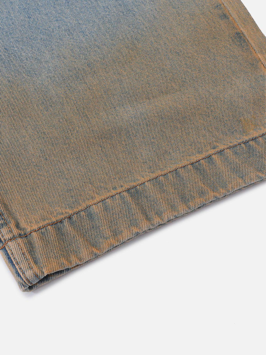 Detailed fabric and stitching of TALISHKO gradient washed jeans, highlighting unique texture.