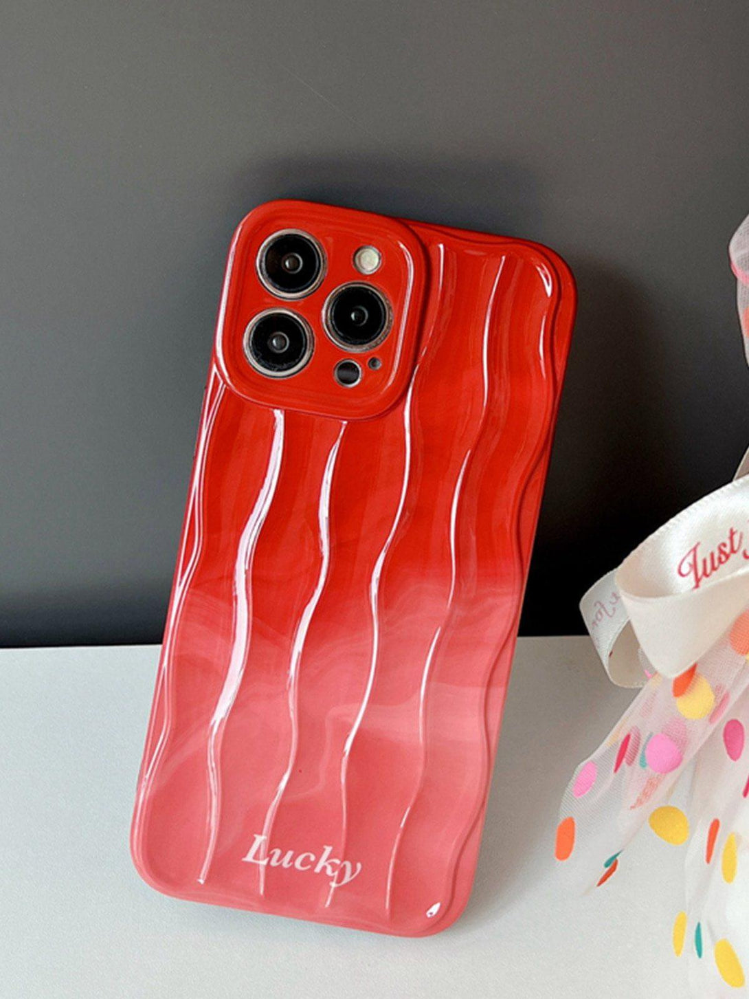 Stylish gradient wavy phone case by TALISHKO, featuring a vibrant red design.