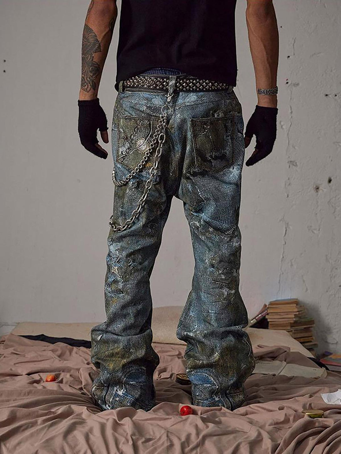 Back view of TALISHKO destruction chain jeans with graffiti design, styled with edgy accessories.