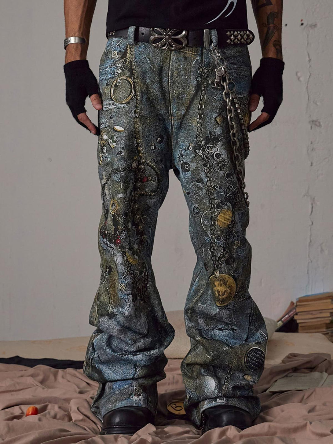Model wearing TALISHKO graffiti-inspired jeans with chain details, paired with black gloves.