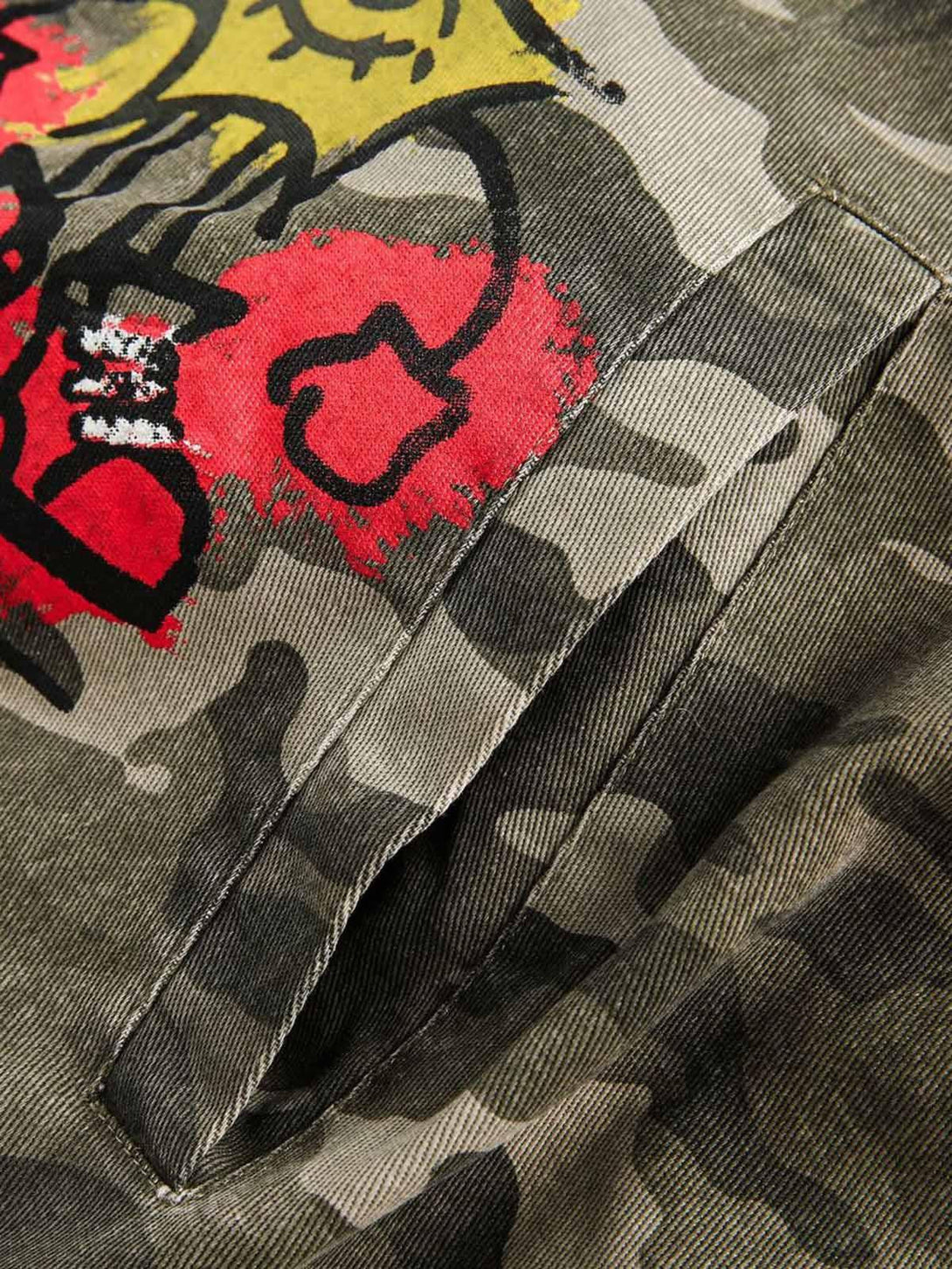 A detailed view of the graffiti and camouflage pattern on a TALISHKO bomber jacket.