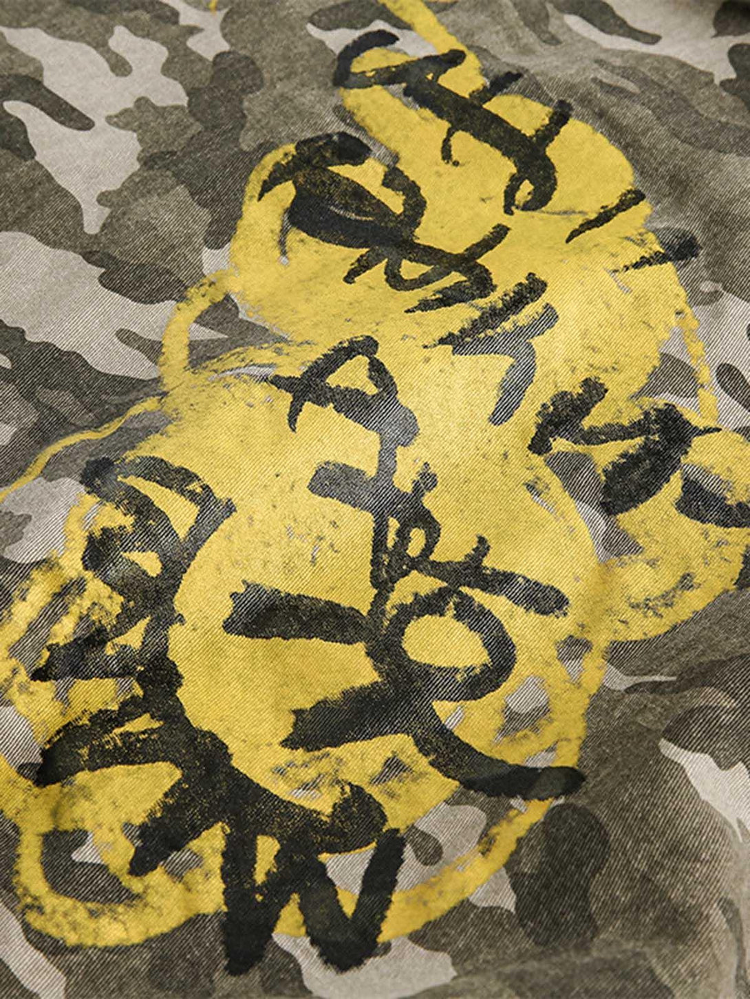 Focusing on the urban graffiti design on a TALISHKO camouflage bomber jacket, highlighting bold style.