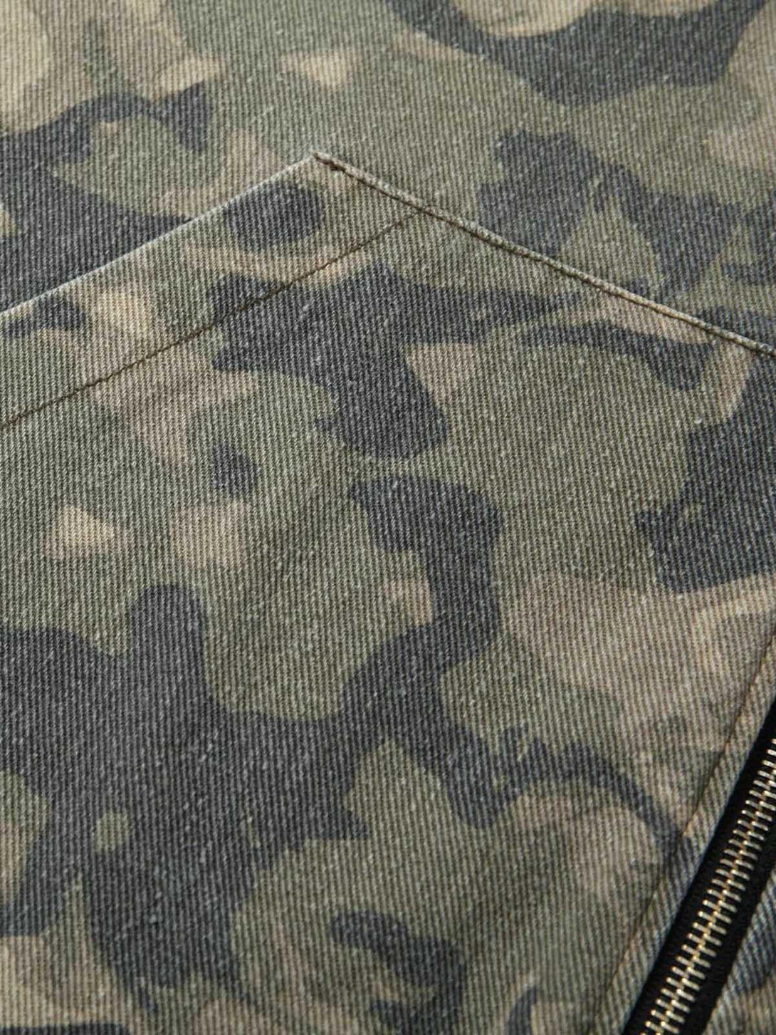 Intricate view of TALISHKO's camouflage fabric and stitching on the patchwork hooded jacket.