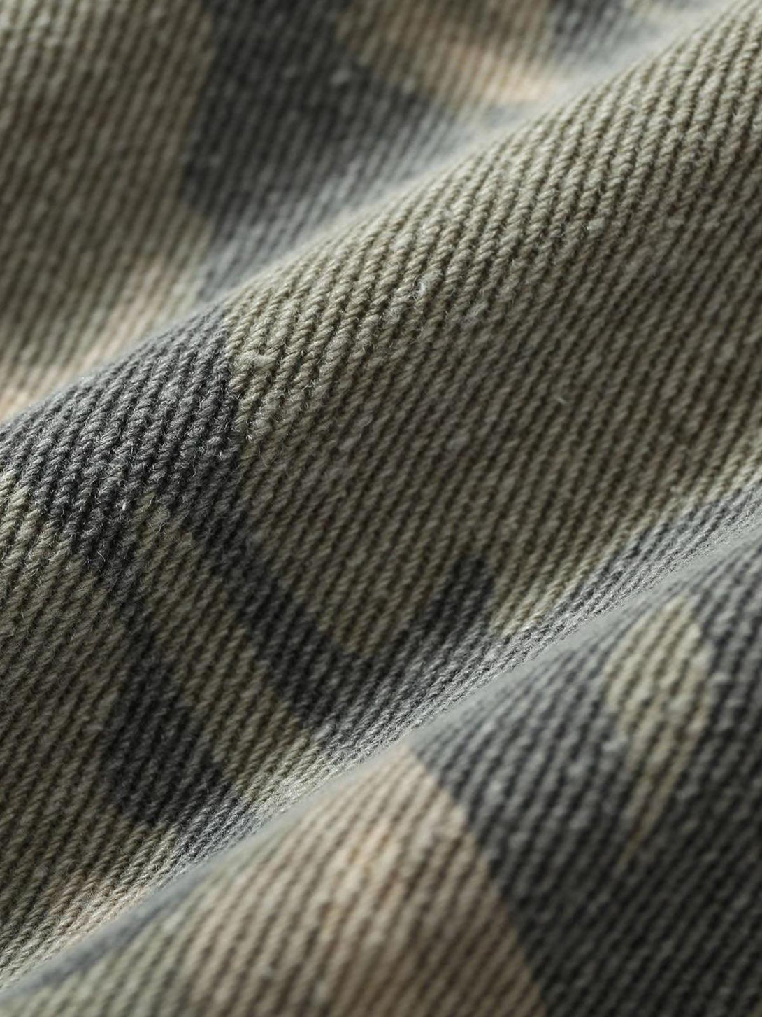 Texture and pattern showcased on TALISHKO's graffiti camouflage patchwork jacket fabric.