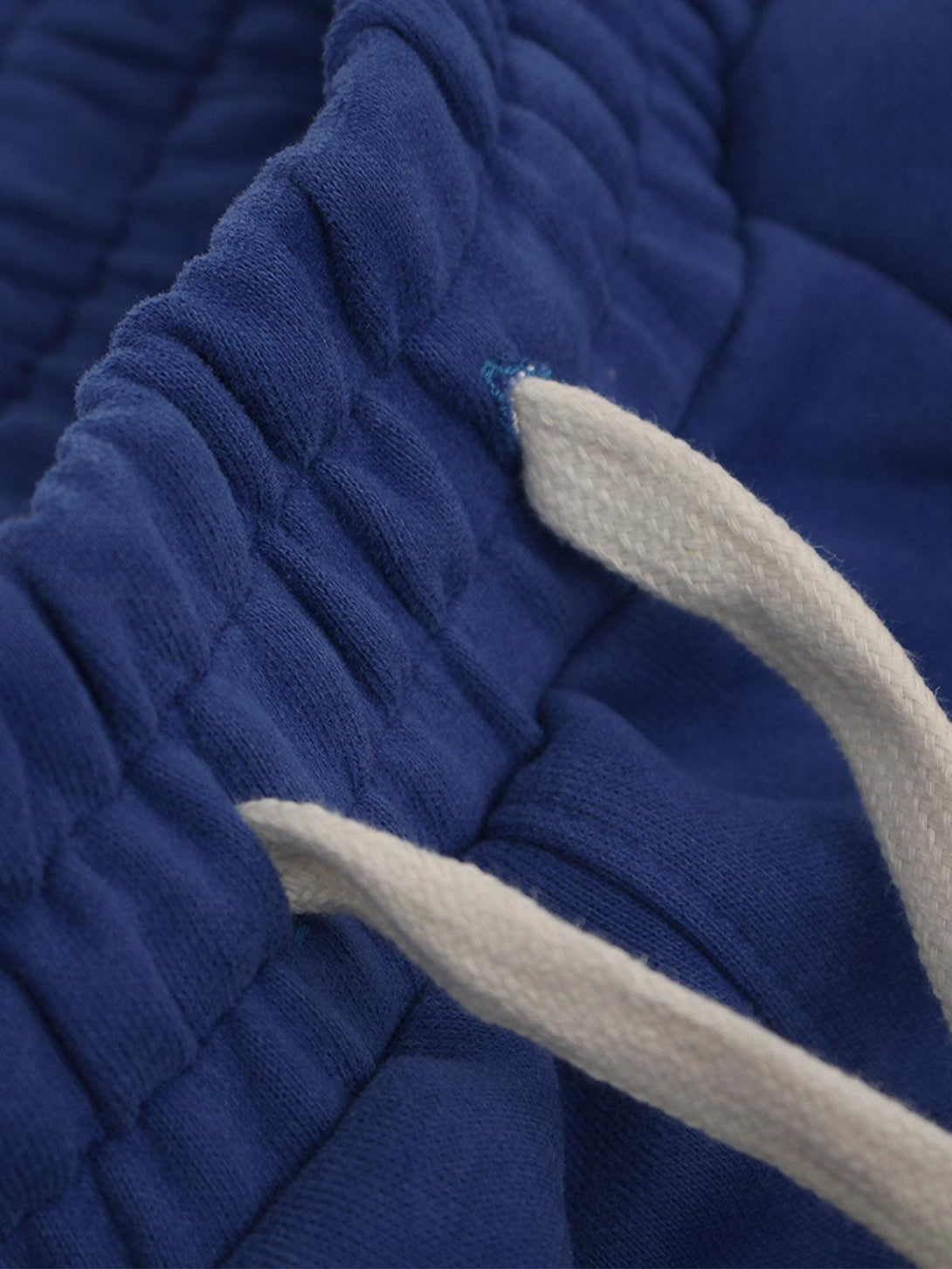 Zoomed-in texture of royal blue cotton shorts by TALISHKO, highlighting drawstring detail.