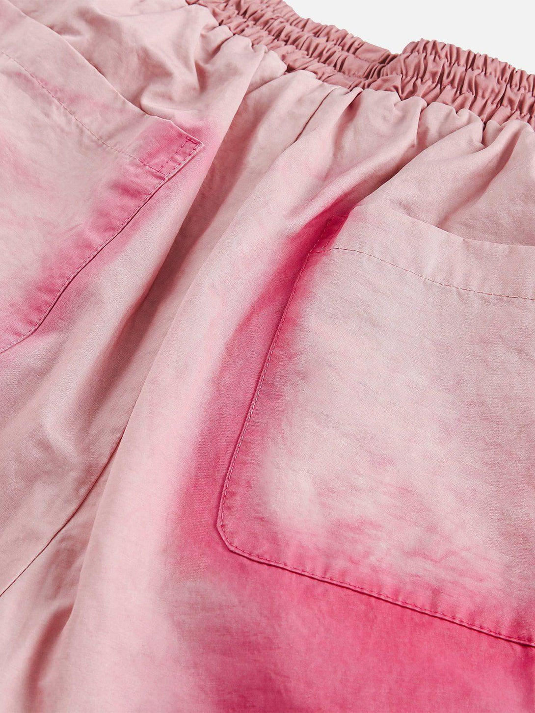 A detailed view of pink drawstring shorts by TALISHKO, highlighting the vibrant fabric texture.
