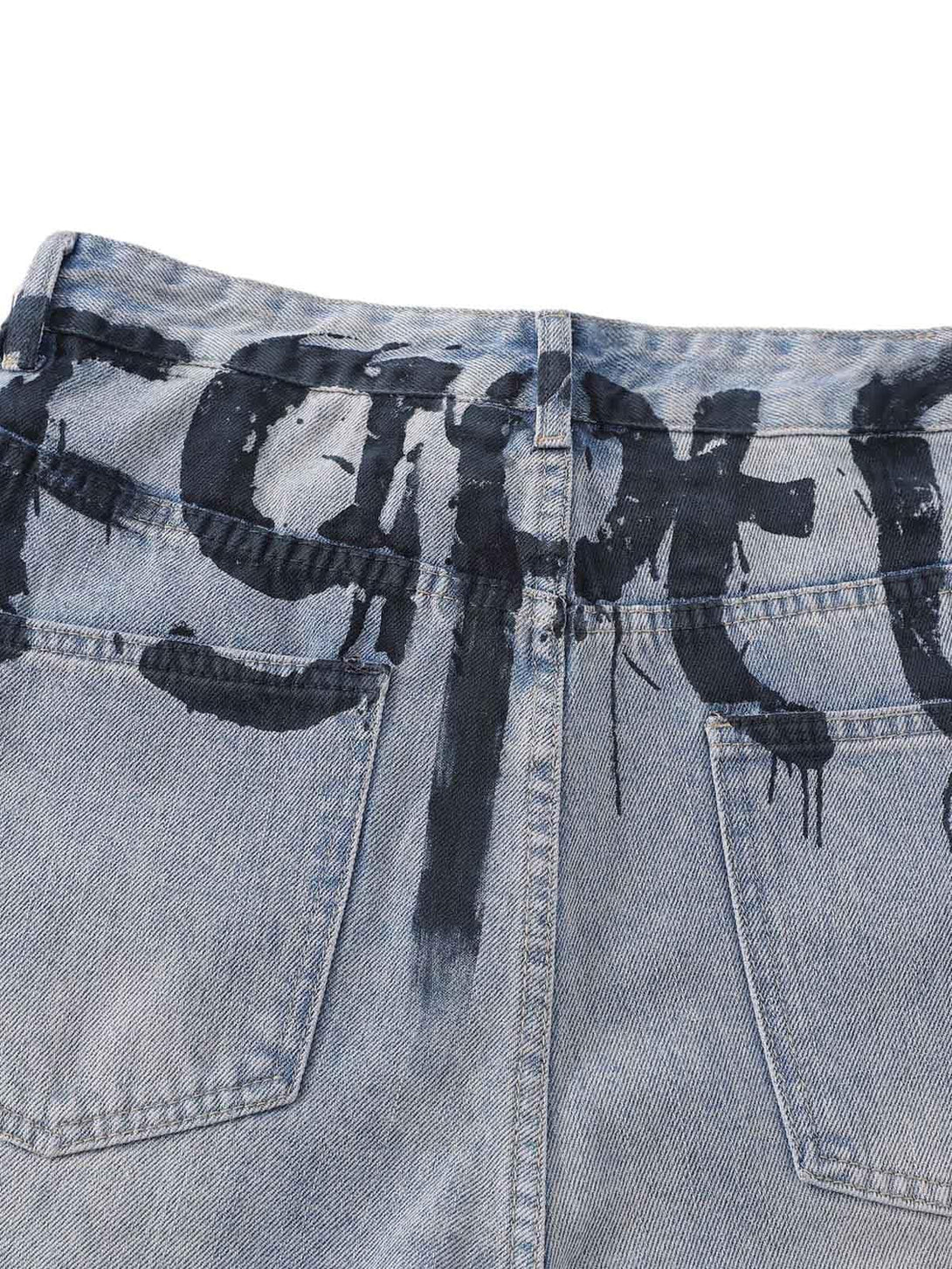 A close-up of TALISHKO denim shorts, highlighting the bold graffiti-style lettering on the back.