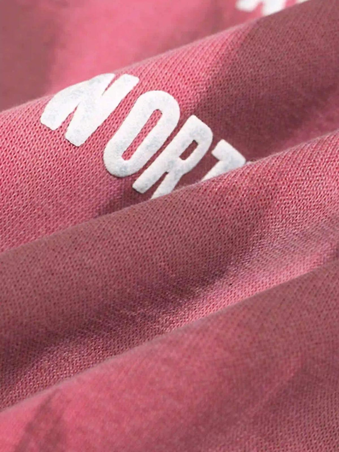 A tight crop highlighting the vibrant pink fabric and bold white lettering of a TALISHKO hoodie.