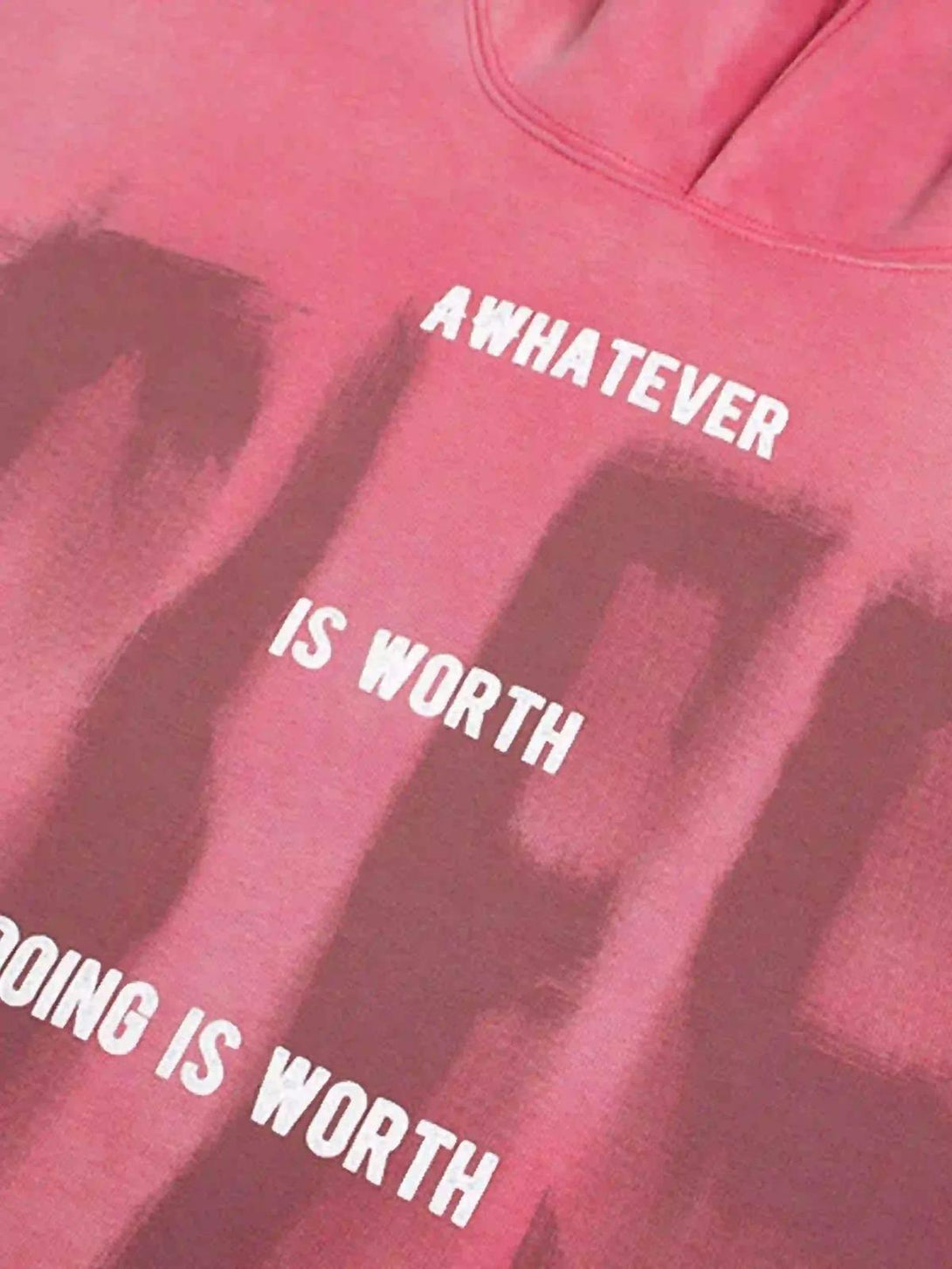 A close-up of TALISHKO's pink gradient hoodie, featuring bold graffiti-style white lettering.