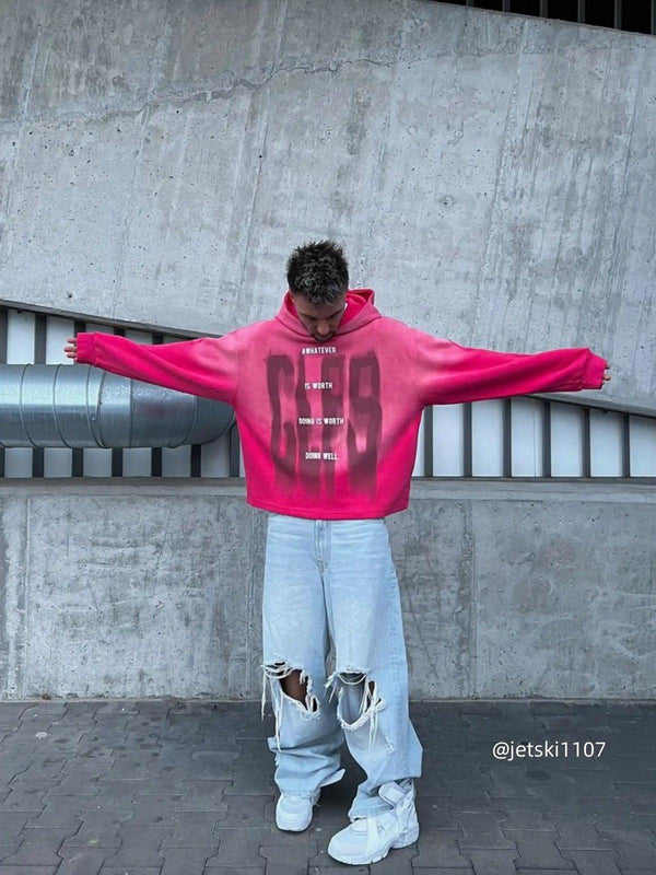 Model wearing a vibrant gradient hoodie by TALISHKO, paired with distressed jeans and sneakers.