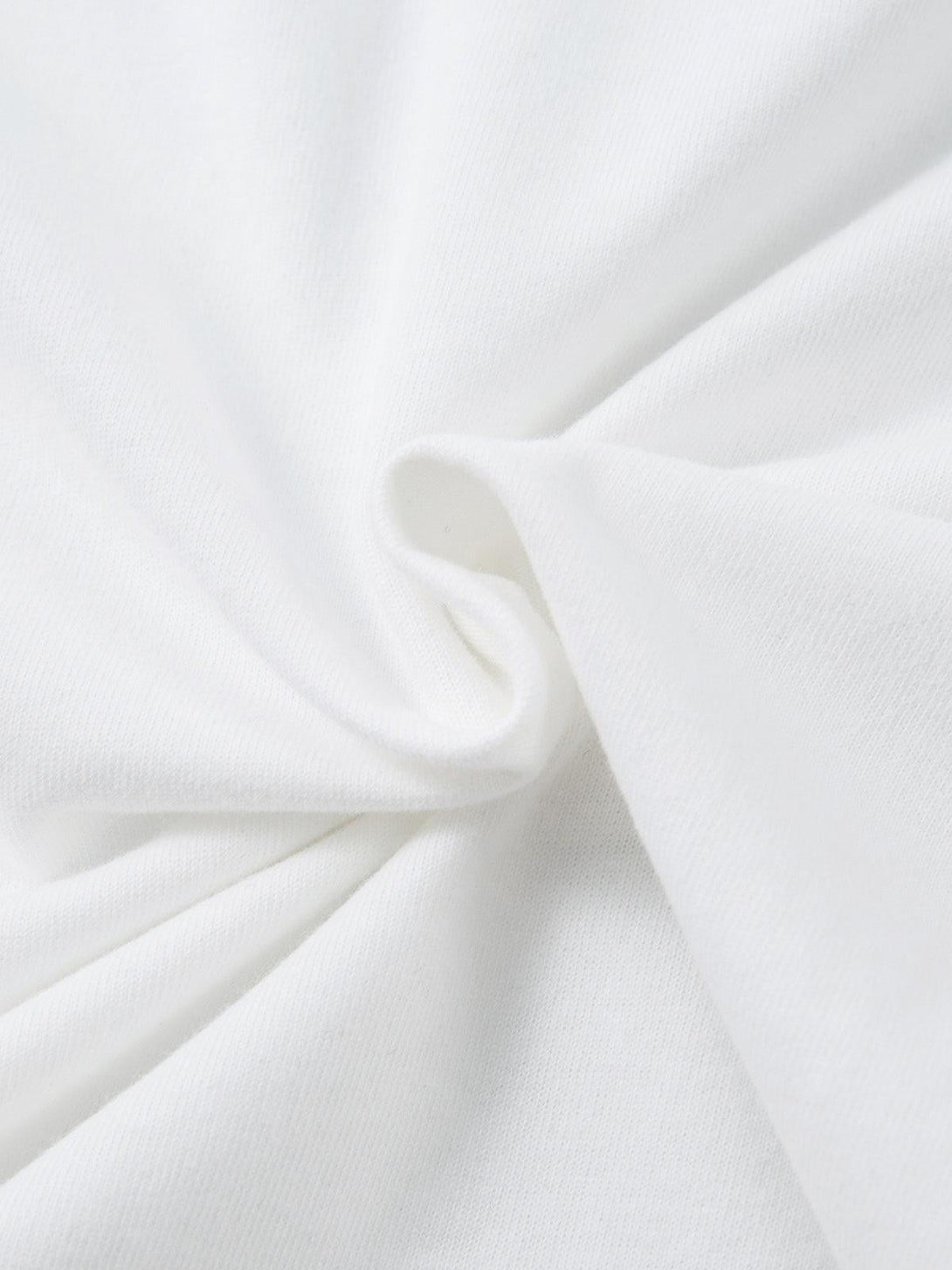 A close-up view of the soft, white fabric of a TALISHKO oversized T-shirt, highlighting its texture.