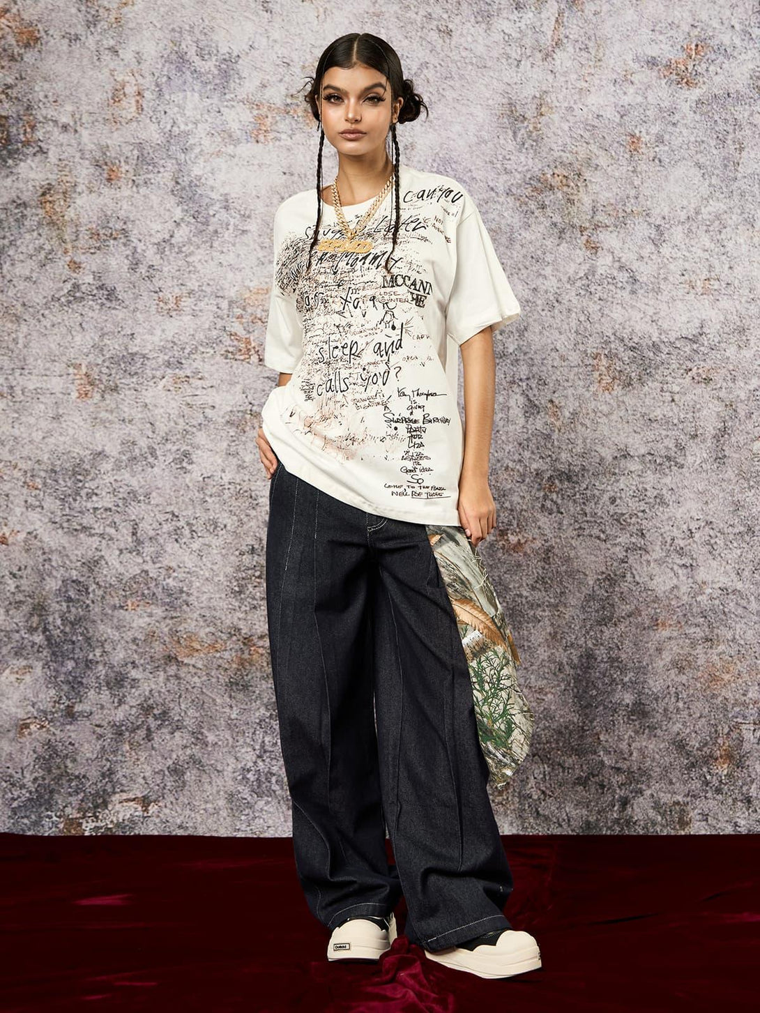 Model in a TALISHKO oversized graffiti print T-shirt, paired with wide-leg jeans and sneakers.