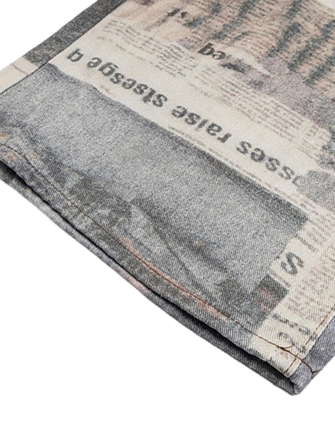 Detailed fabric and stitching of TALISHKO's graffiti newspaper baggy jeans, showcasing unique style.