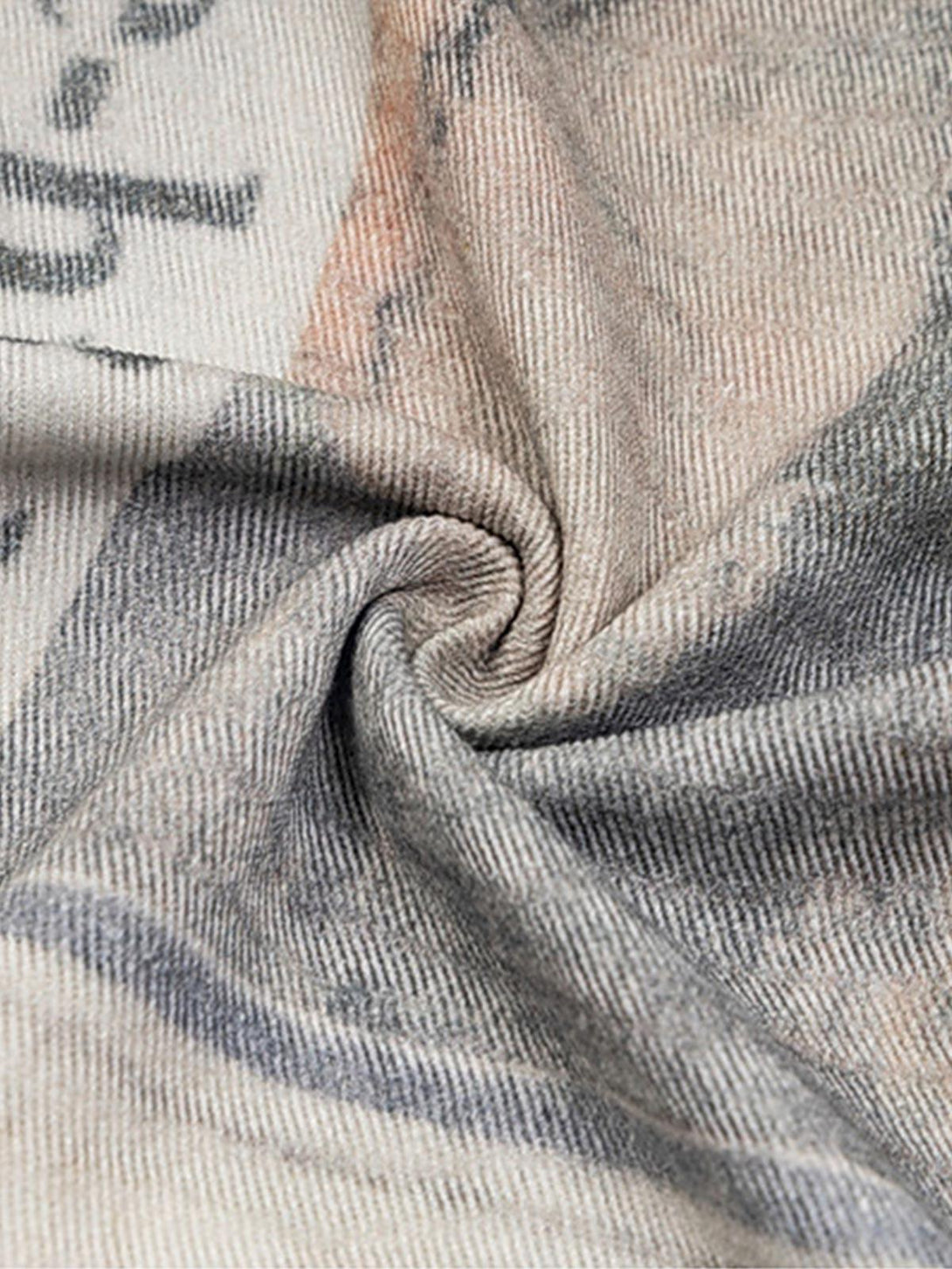 Zoomed-in texture of TALISHKO's graffiti newspaper jeans, highlighting unique fabric details.