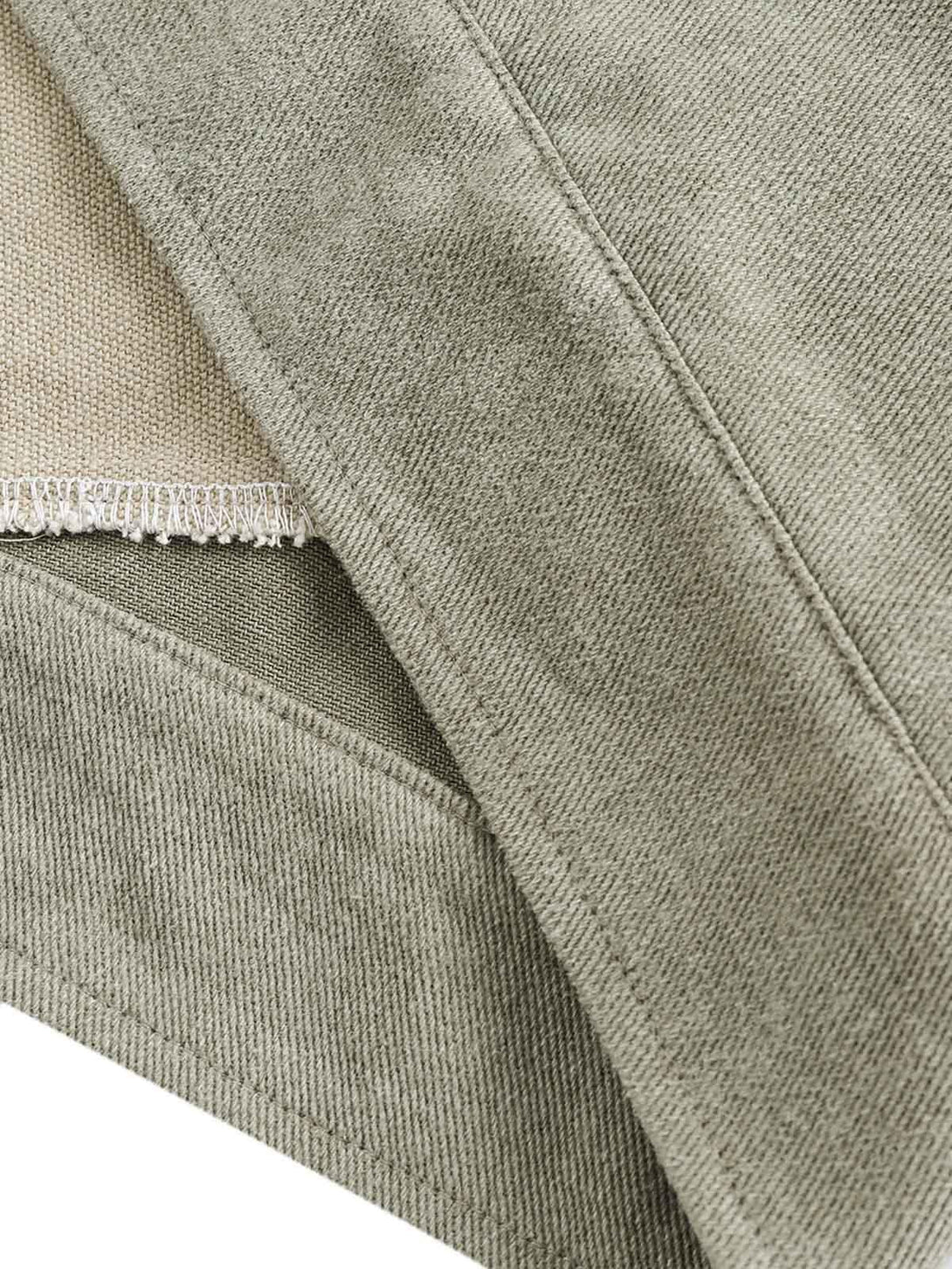 A detailed view of the textured denim fabric and stitching on the jacket by TALISHKO.