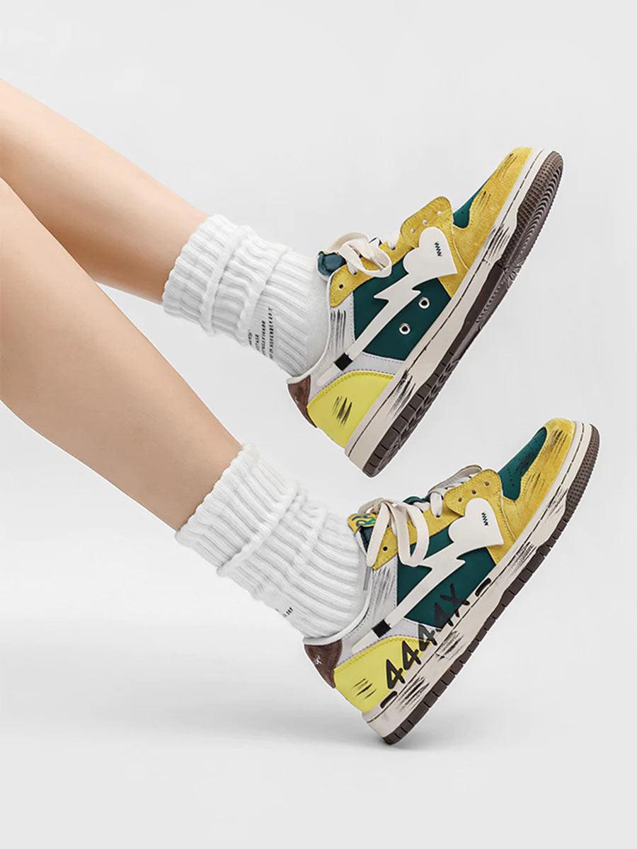TALISHKO graffiti skate shoes in yellow and green, worn with white socks for a bold look.