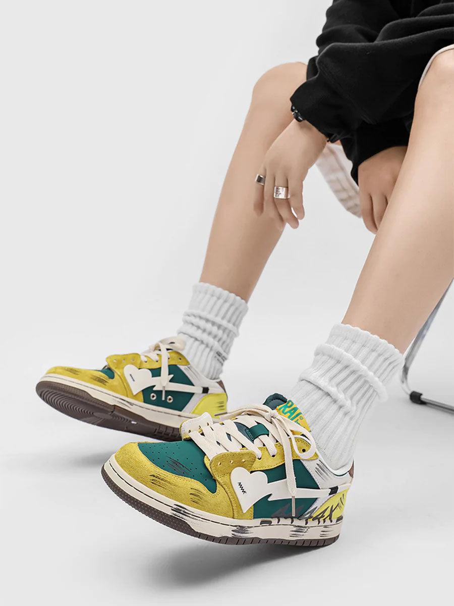 TALISHKO graffiti skate shoes in vibrant yellow and green, worn with white socks and a black outfit.