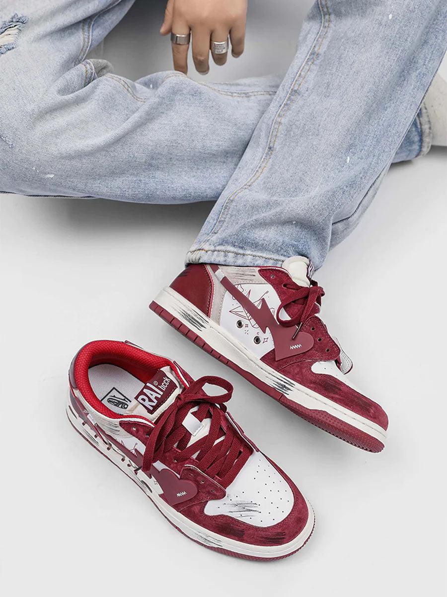 TALISHKO graffiti skate shoes in red and white, paired with ripped jeans for a casual vibe.