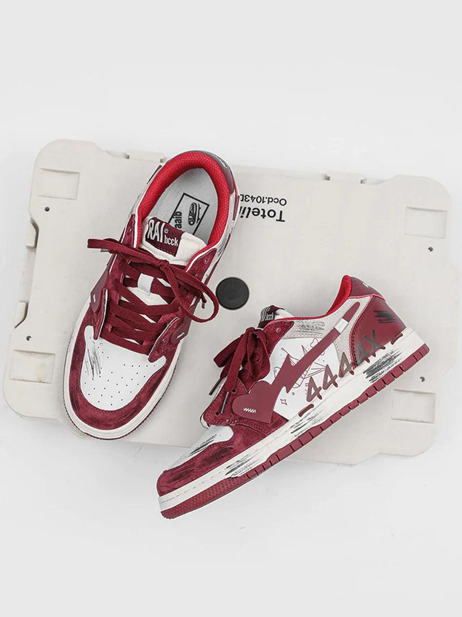 TALISHKO graffiti skate shoes in red and white with unique side designs on a neutral backdrop.