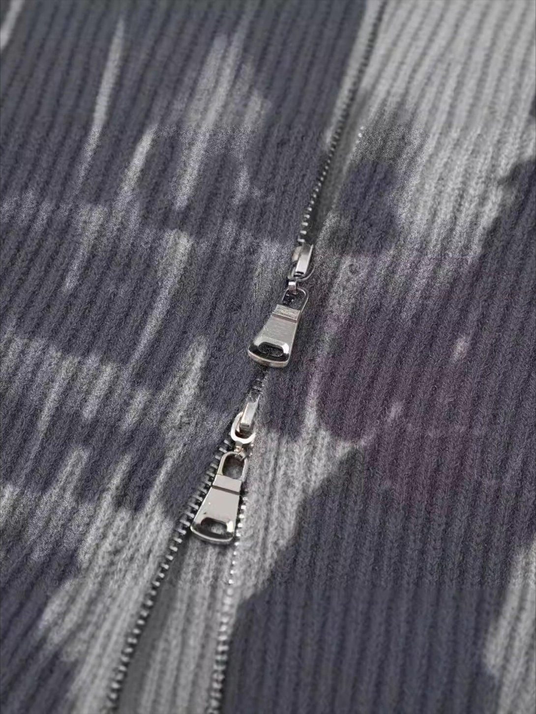 Intricate look at the zipper detail on TALISHKO's graffiti-patterned cardigan, showcasing texture.