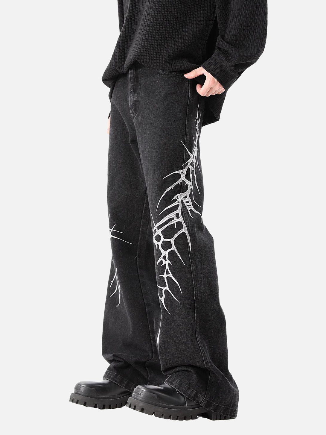 Model wearing TALISHKO graphic embroidered straight jeans with striking side detailing.