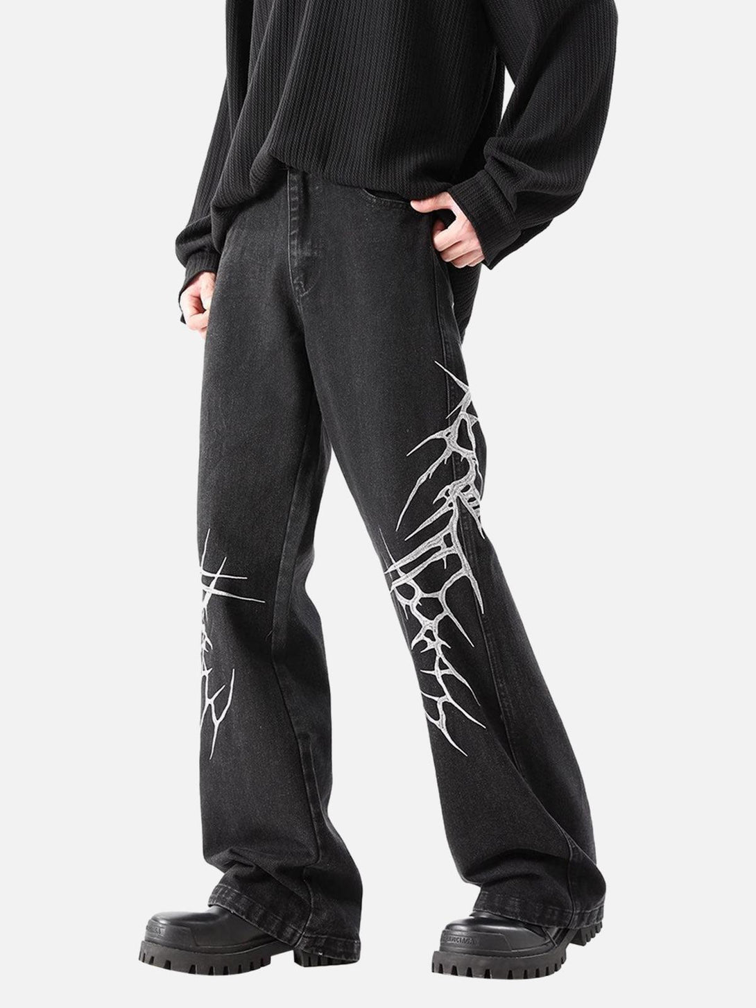 Model in TALISHKO graphic embroidered straight jeans, featuring bold design elements on sides.